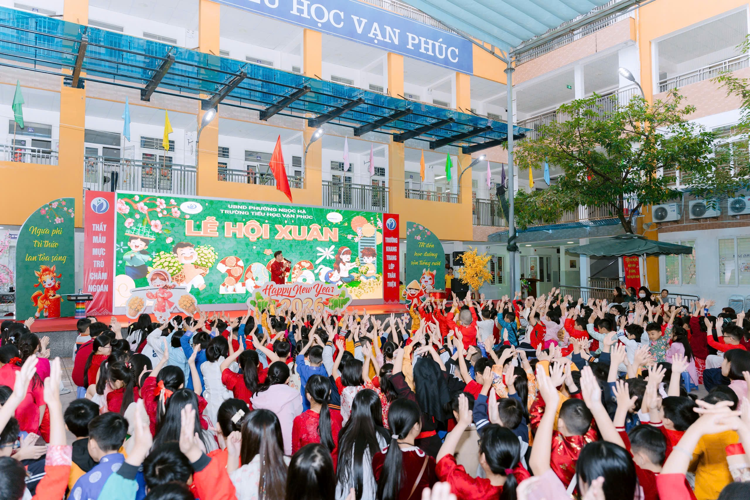 A group of people in a room with a stage and a sign
Description automatically generated