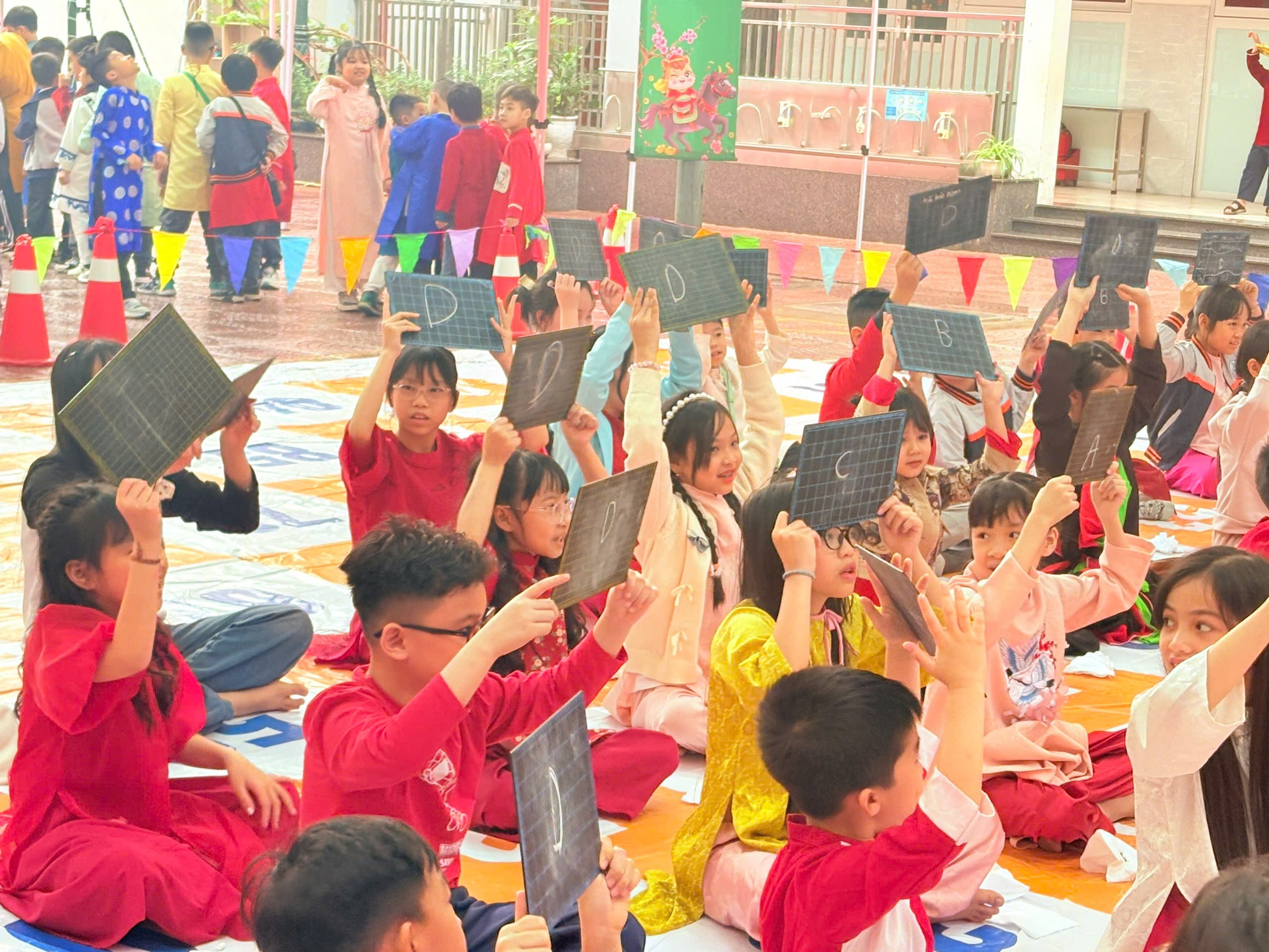 A group of children sitting on the floor holding up solar panels
Description automatically generated