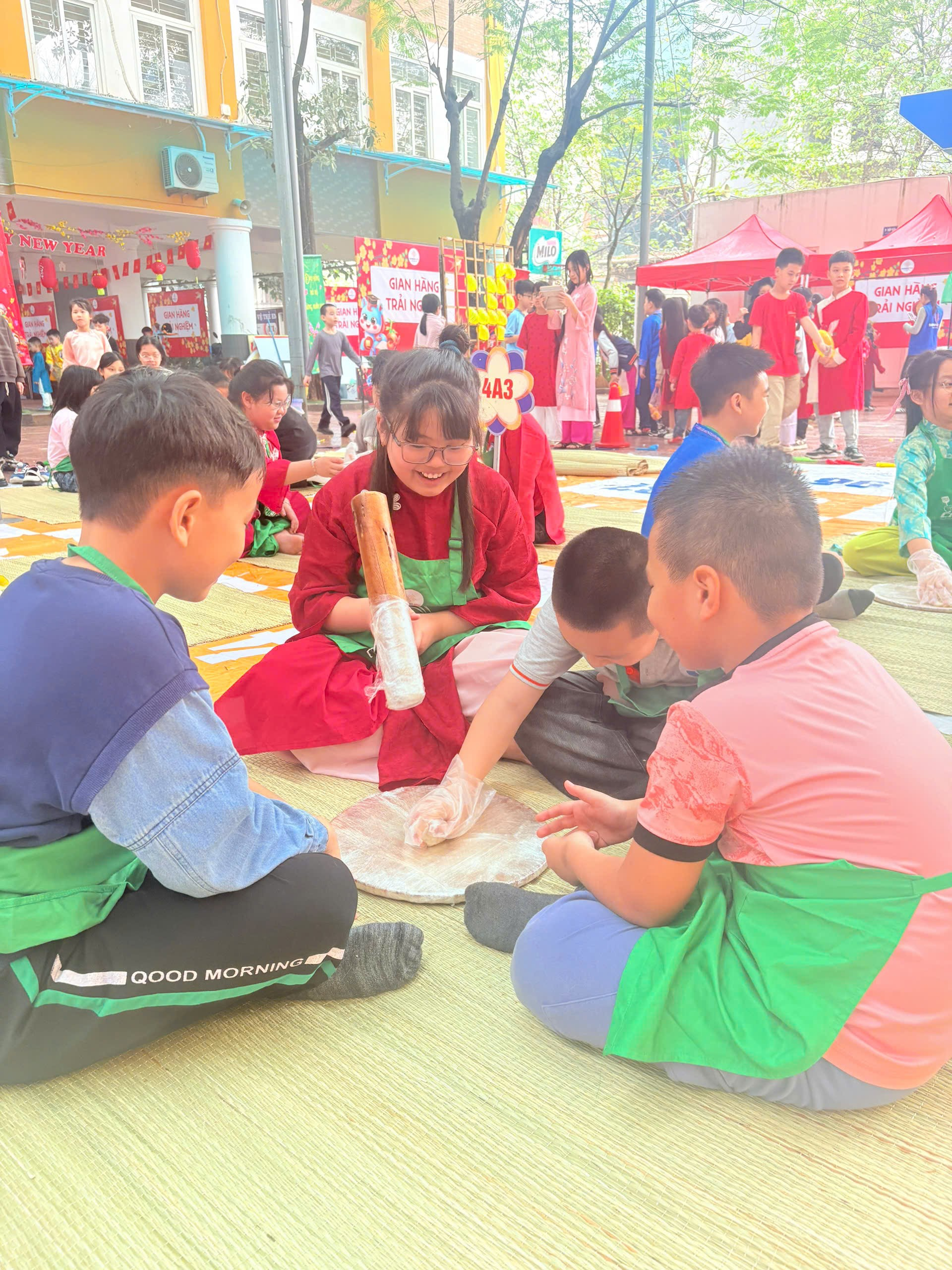 A group of kids sitting on the ground
Description automatically generated