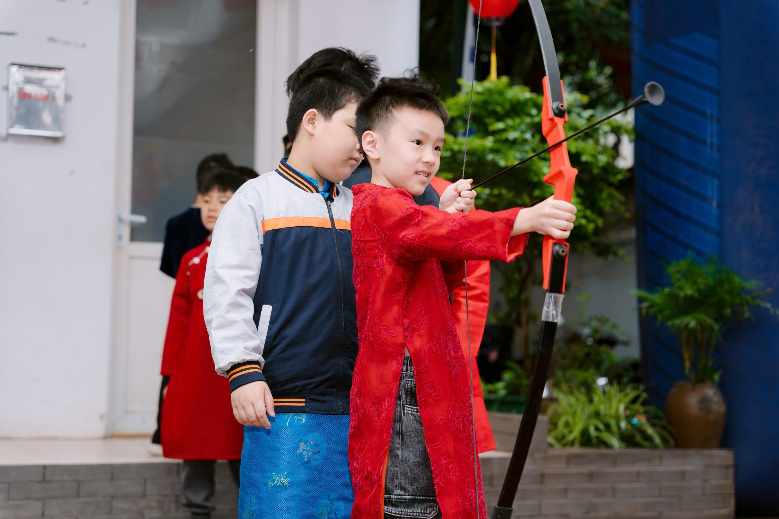 A child holding a bow and arrow
Description automatically generated